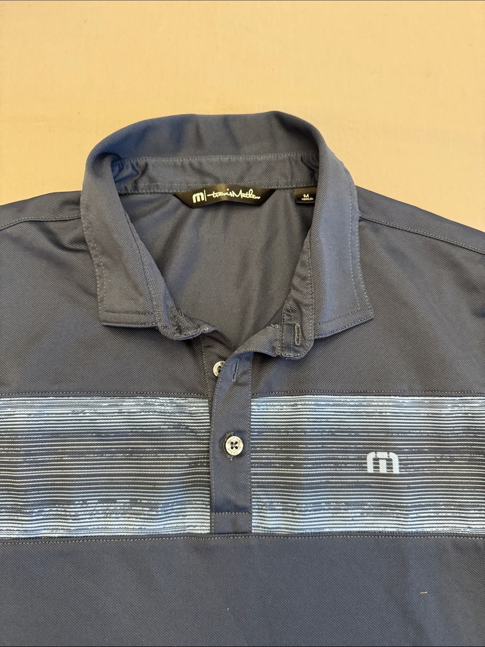 Travis Mathew Navy Polo with Light Blue Stripe Panel